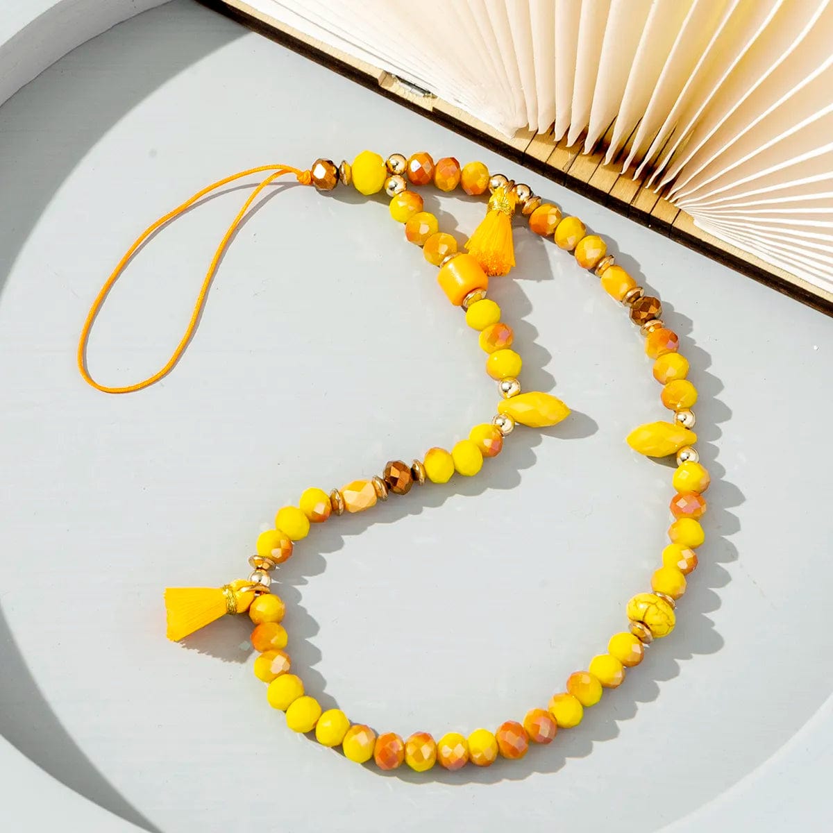 Gelbe Perlen-Handykette mit Pompons